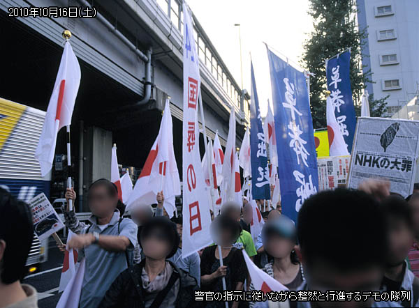 警官の指示に従いながら整然と行進するデモの隊列